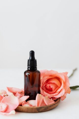 Oil bottle surrounded by rose petals.