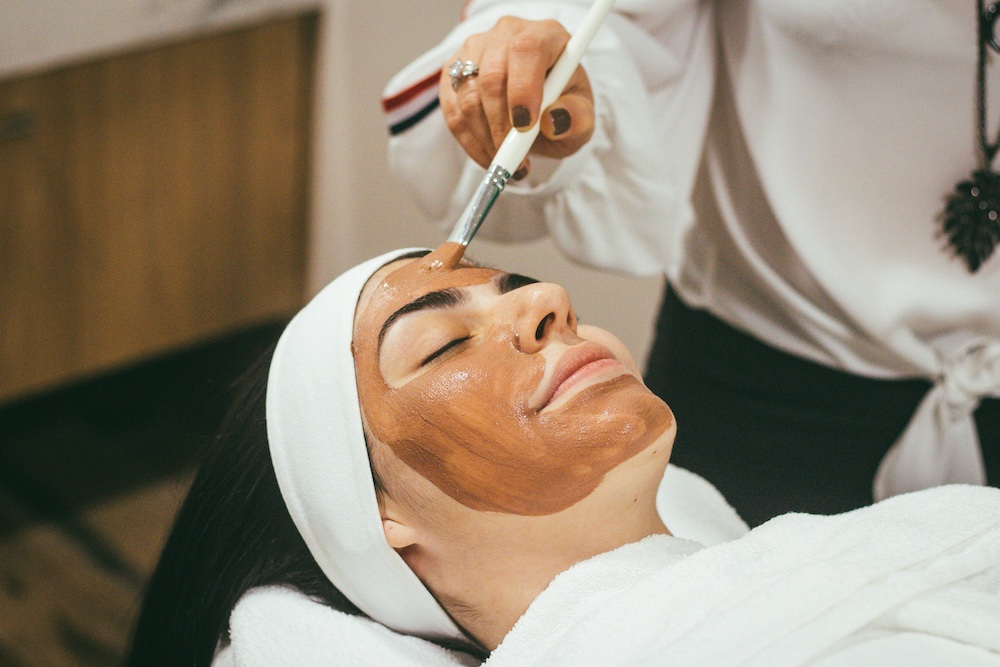 Woman relaxing while receiving a facial treatment.