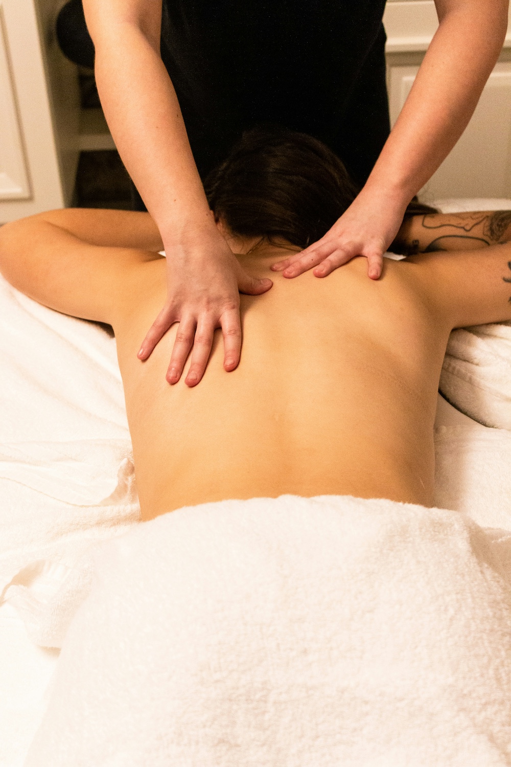 Woman lying down with two hands giving a massage.